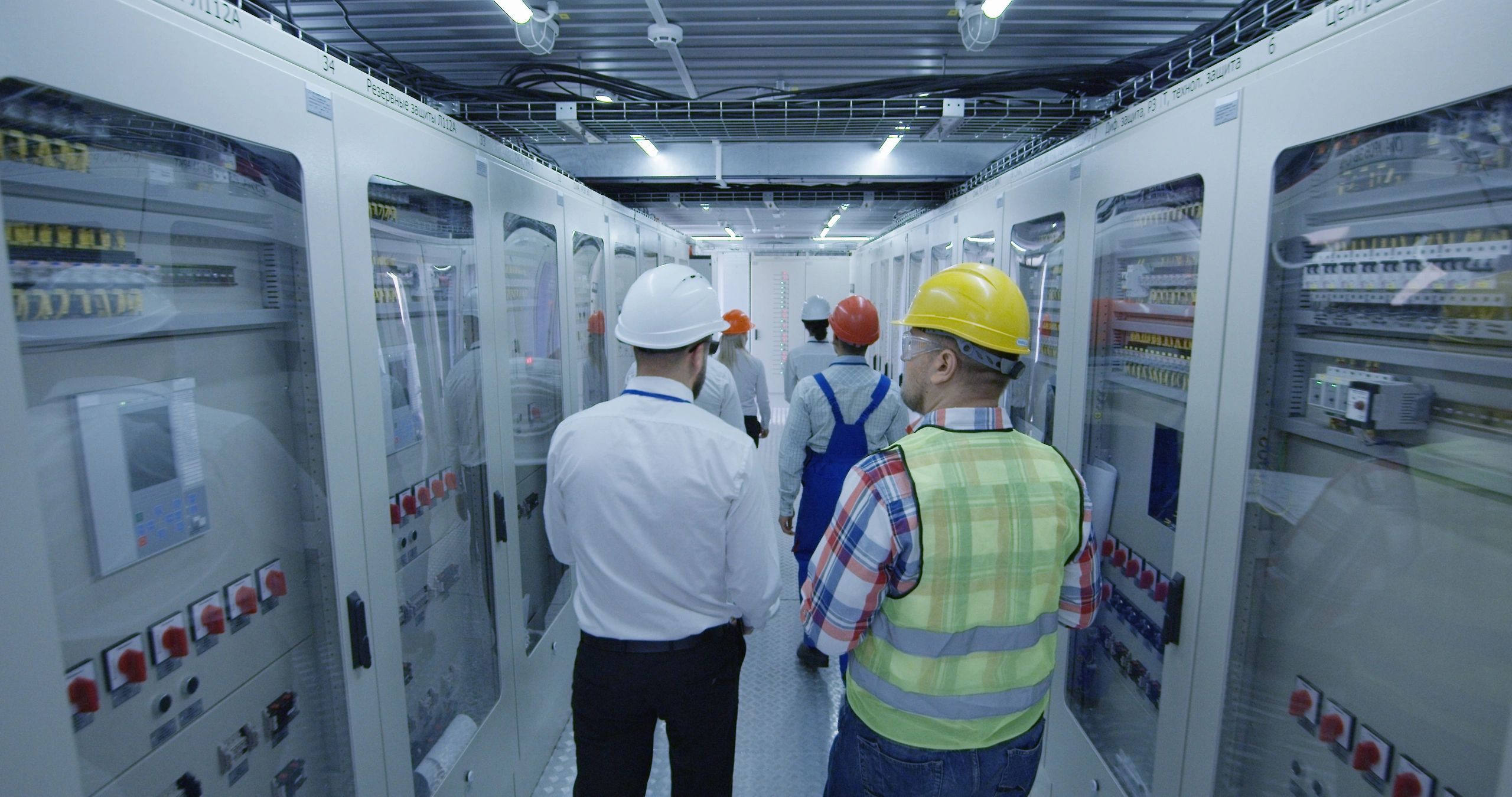Electrical workers reviewing plans in a control room