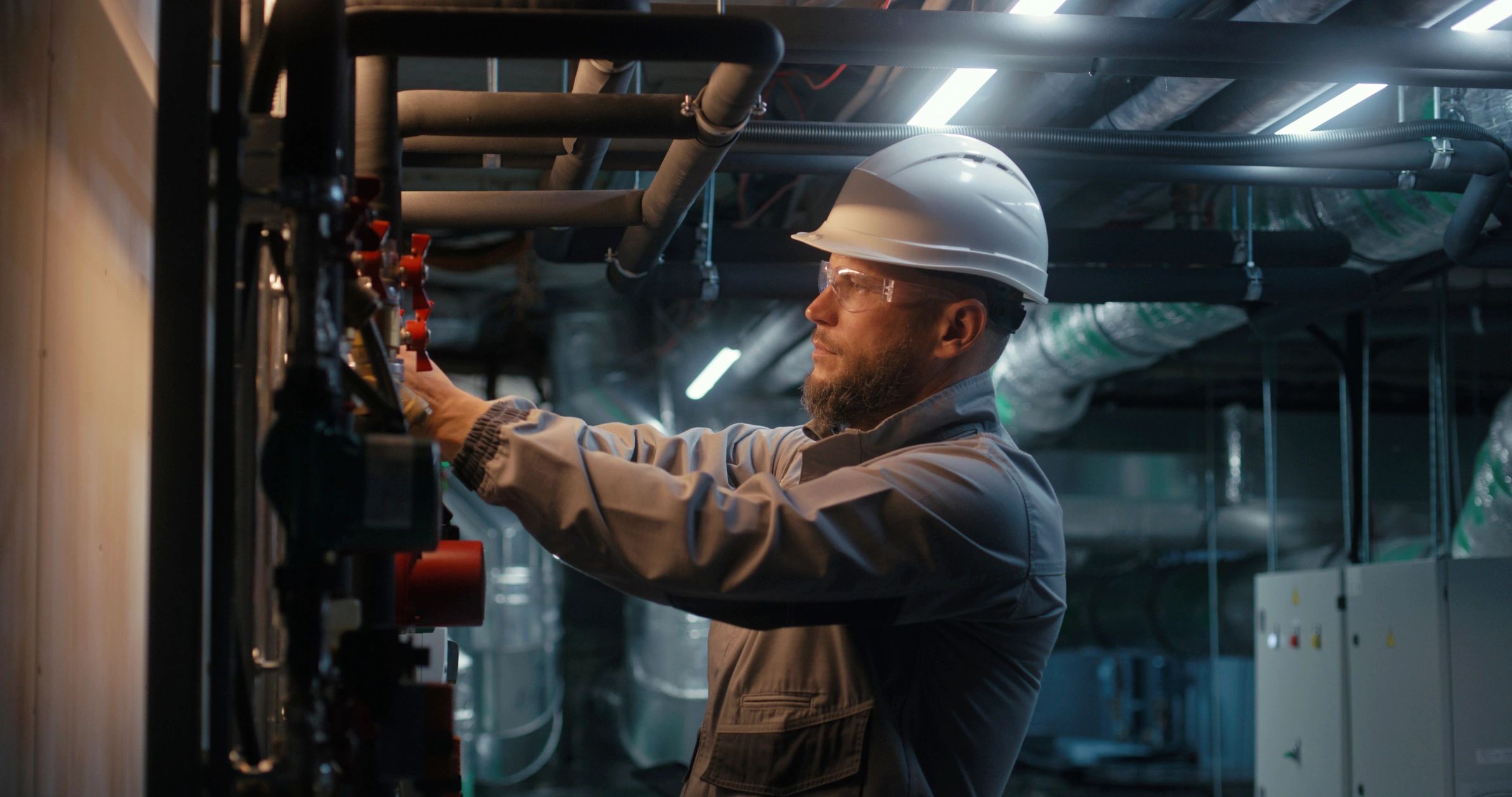 Worker inspecting industrial systems with safety equipment